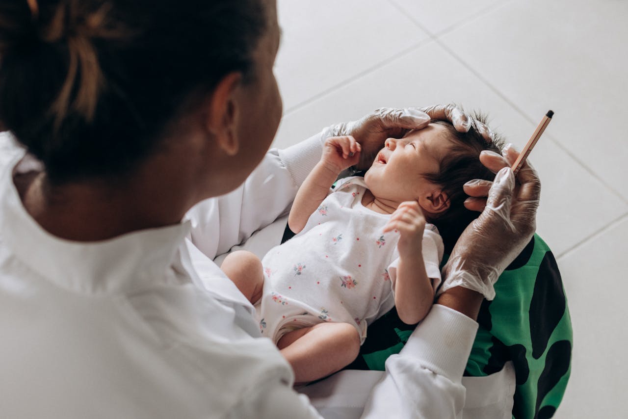 about-img A medical professional examines a newborn baby indoors, highlighting healthcare and care.