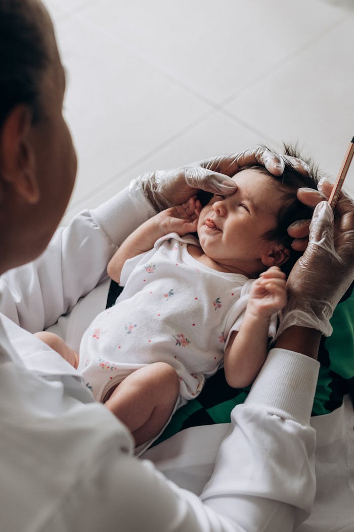 gallery-1 A healthcare professional examines a newborn baby indoors, demonstrating care and attention.
