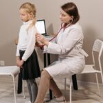 dr ainur zholdasbekova checkup A pediatrician conducting a health checkup on a child in a clinic setting.