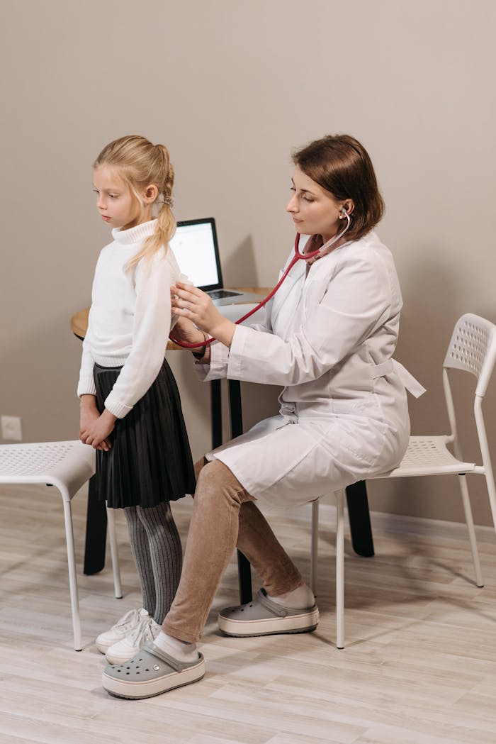 A pediatrician conducting a health checkup on a child in a clinic setting.