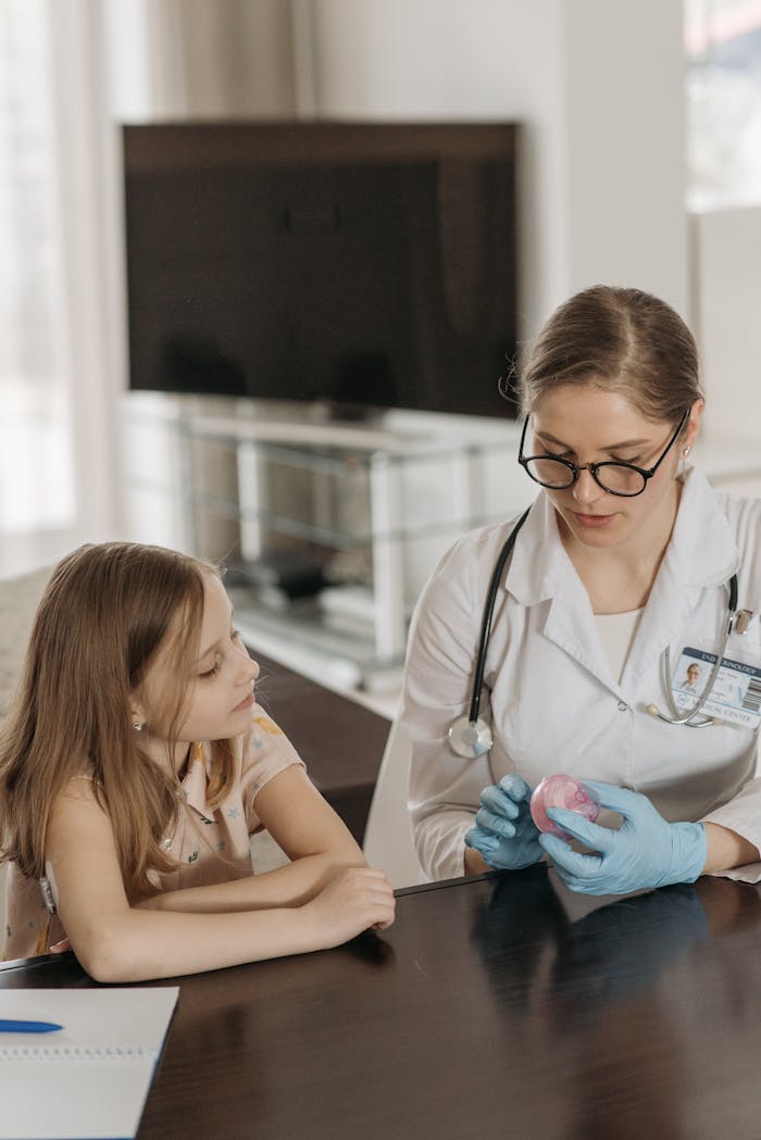 gallery-5 A female doctor explains a medical concept to a young girl during a home visit.